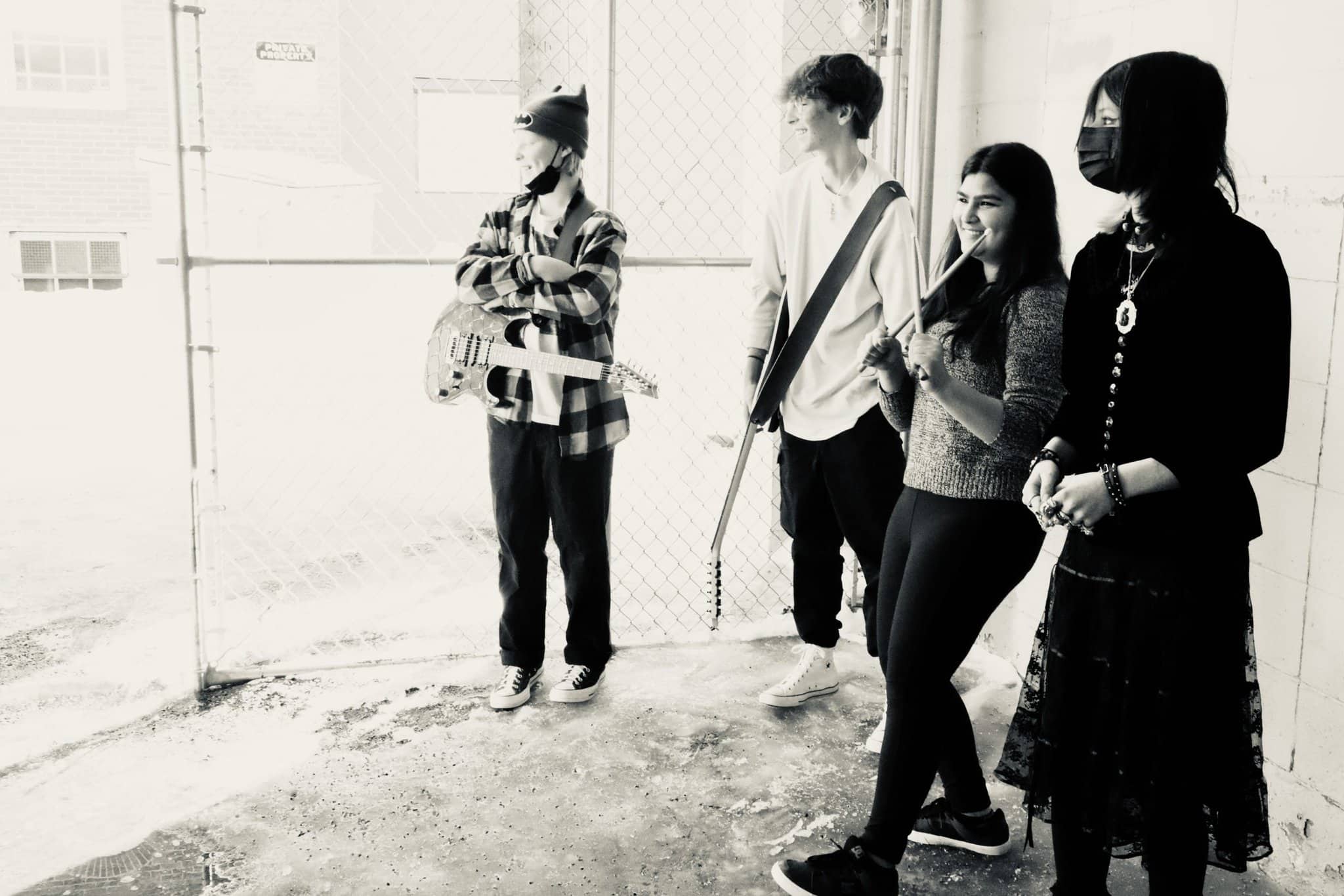Shambhavi Pachauri's Rock Band at Backbeat Teenage rock band posing in back alley with guitars and drum sticks.
